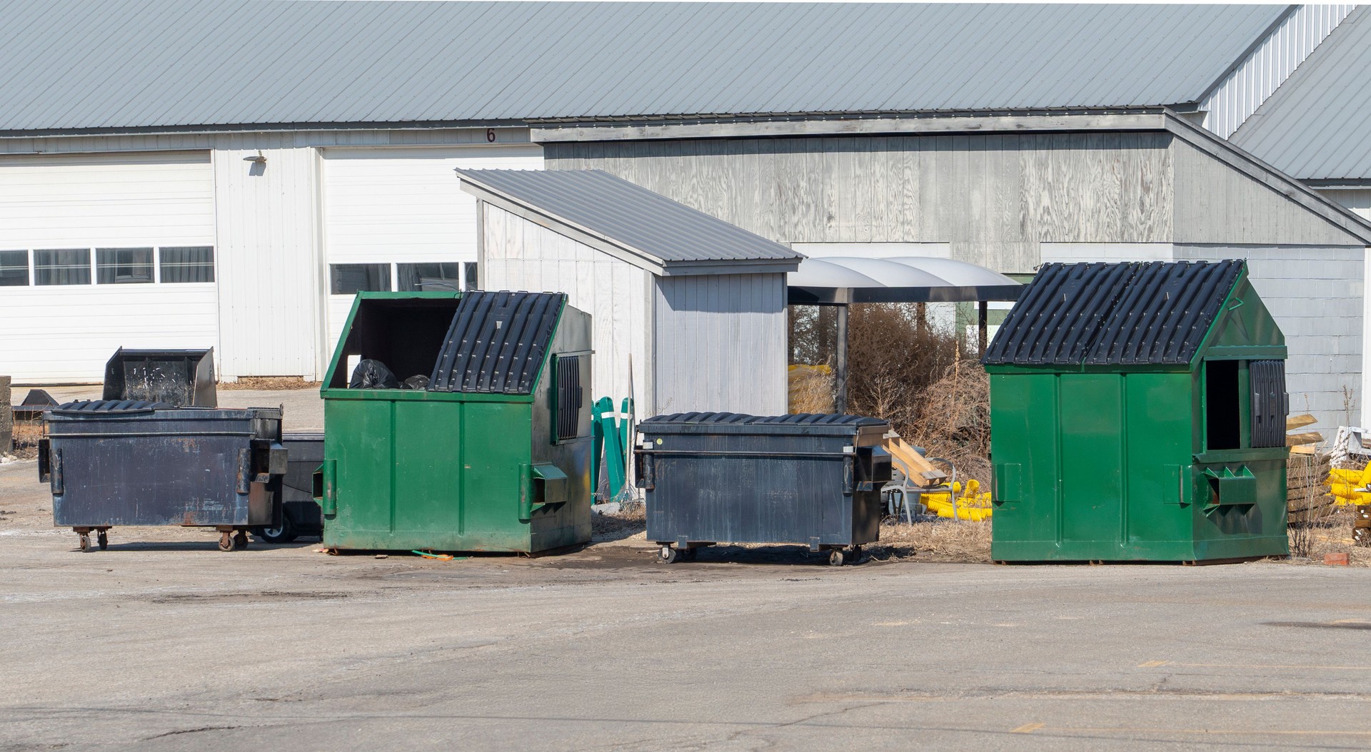 commercial dumpster for trash and recycling outside warehouse